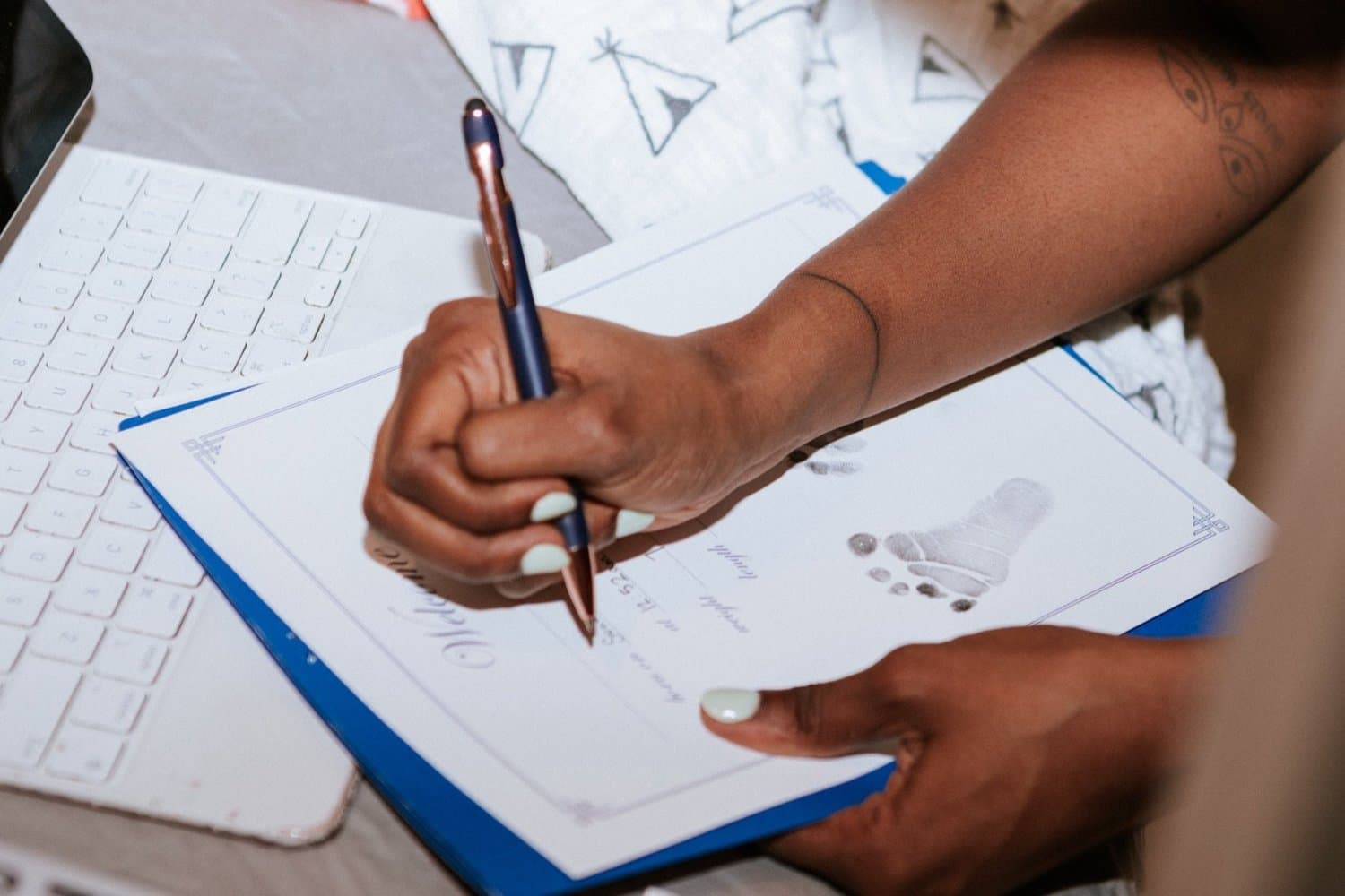 Abiana completing a newborn's birth certificate with a tiny inked footprint